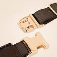 Load image into Gallery viewer, Close up of gold quick release buckle and brown leather strap on adjustable dog harness