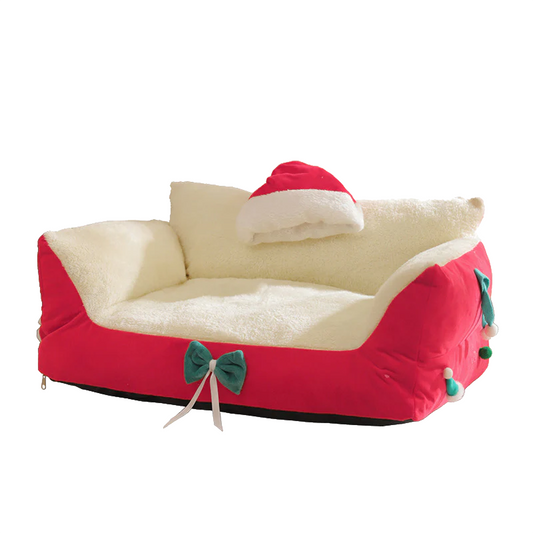 Cozy Christmas Pet Sofa Bed Product View – Red with Cream Interior, Santa Hat Pillow and Green Bow | GraviPaw