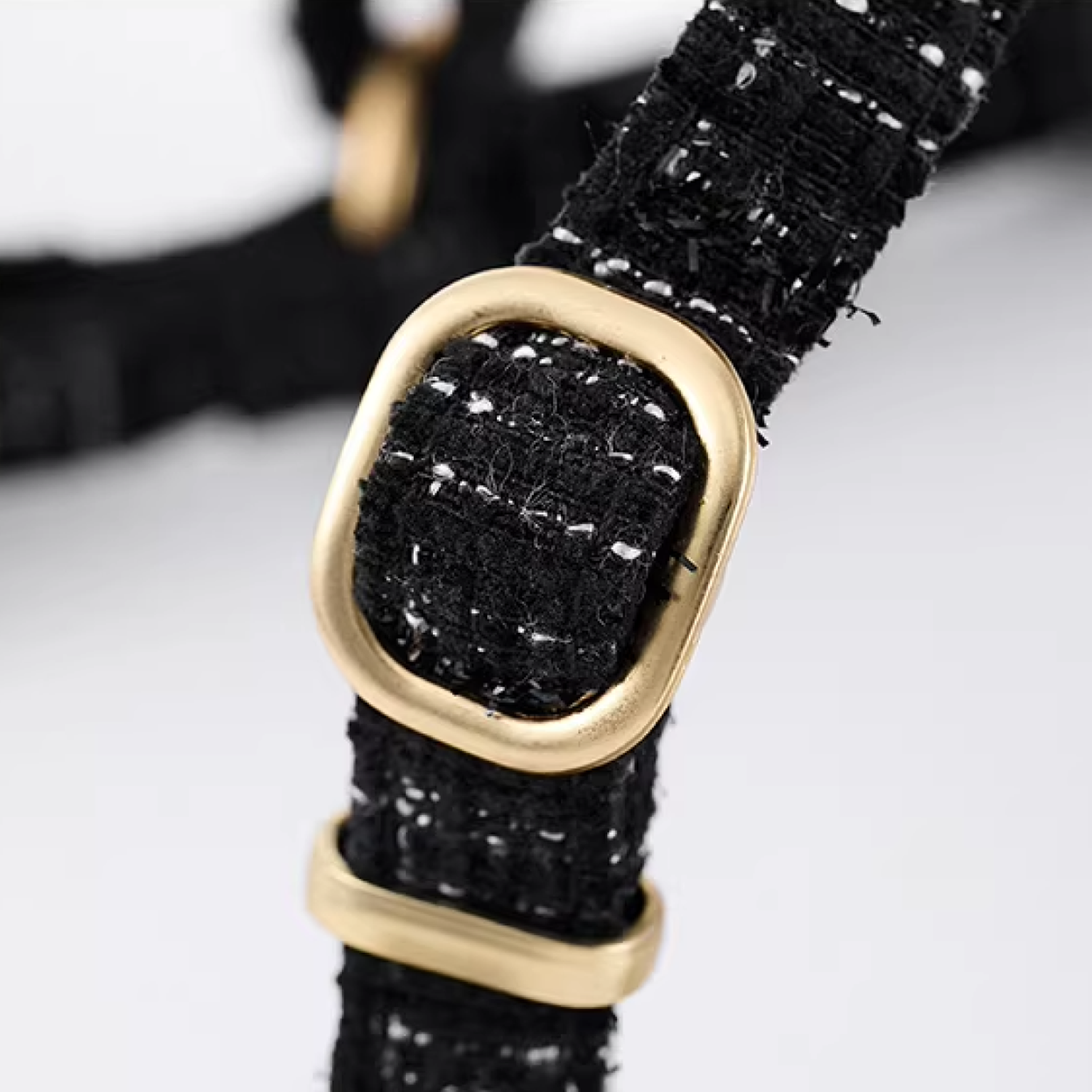 Black tweed adjustable strap with gold buckle hardware detail
