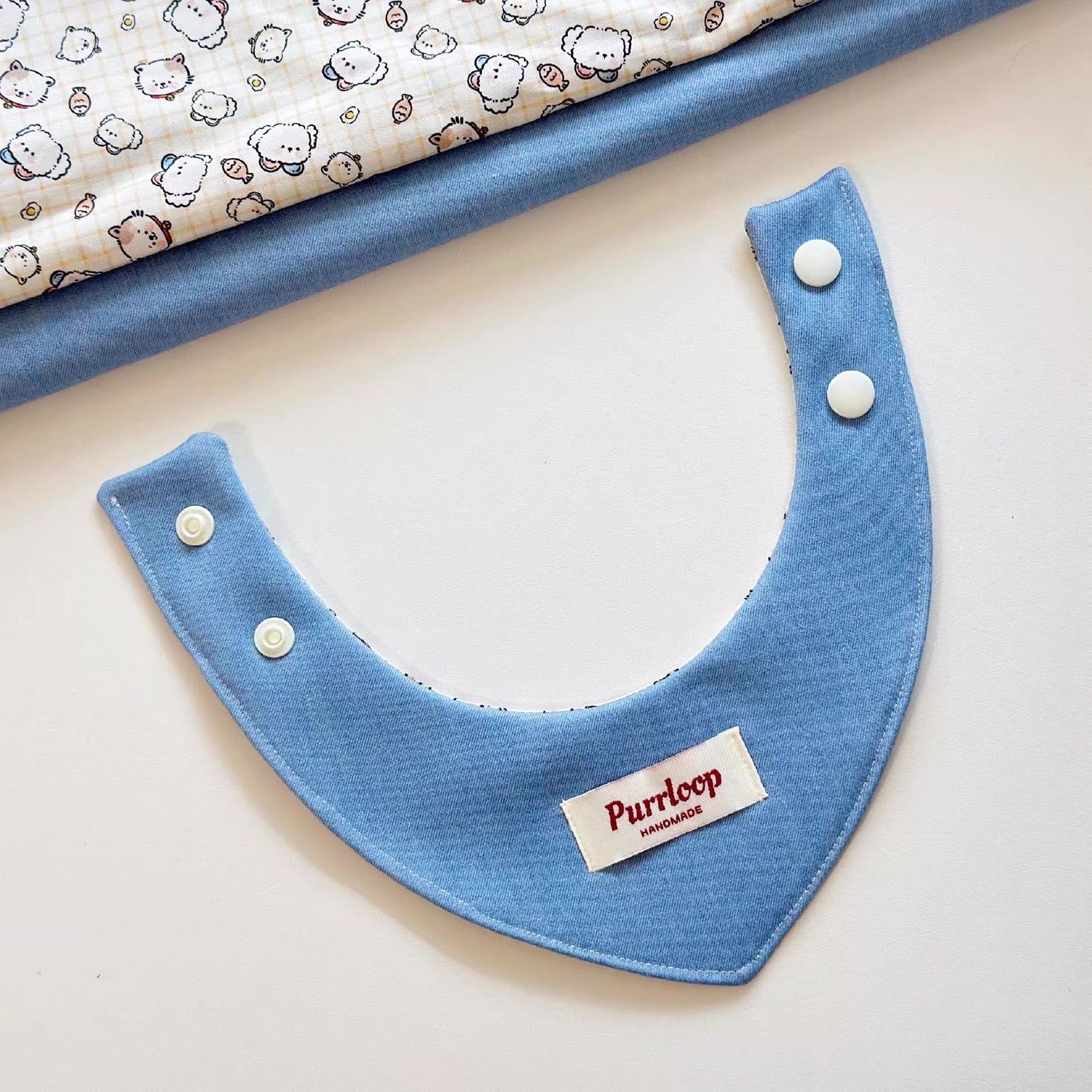 Flat lay of solid blue side reversible cotton pet bandana collar
