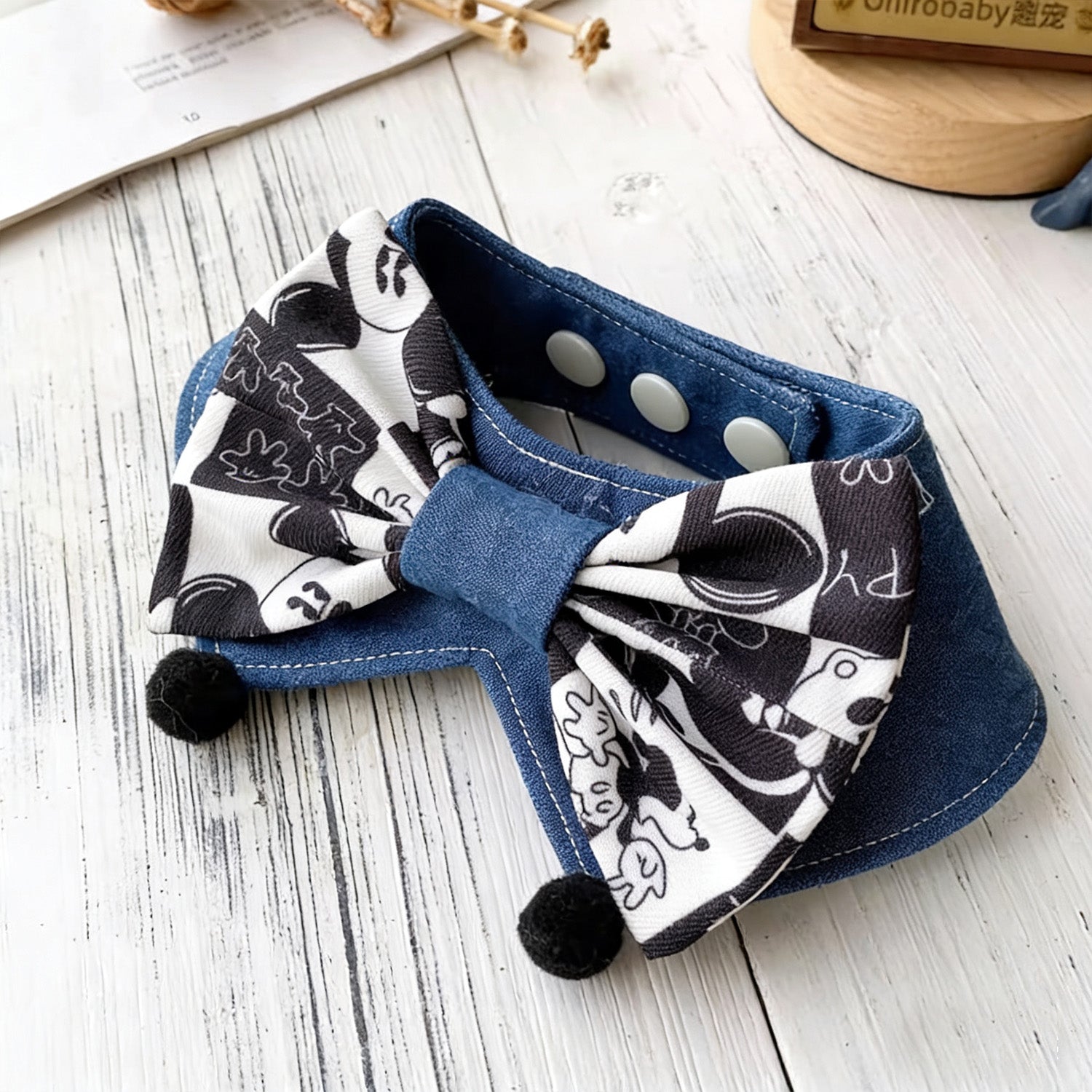 Blue denim pet collar with black and white cartoon print bow and pom-pom detail
