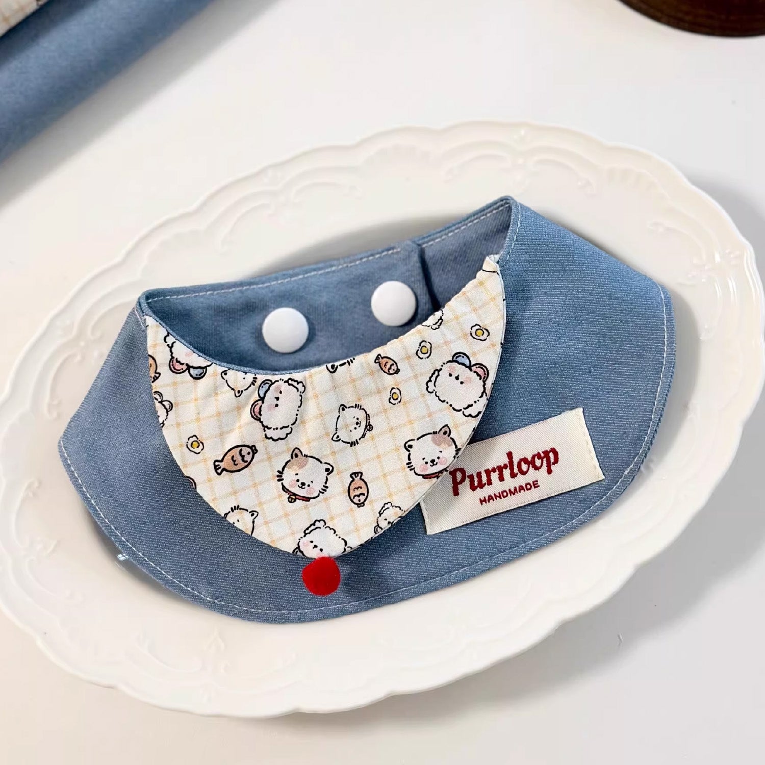 Blue denim cartoon print pet collar with structured shape on white plate