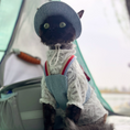 Load image into Gallery viewer, Dark-colored cat wearing GraviPaw denim harness with red bow in outdoor setting with backpack in background
