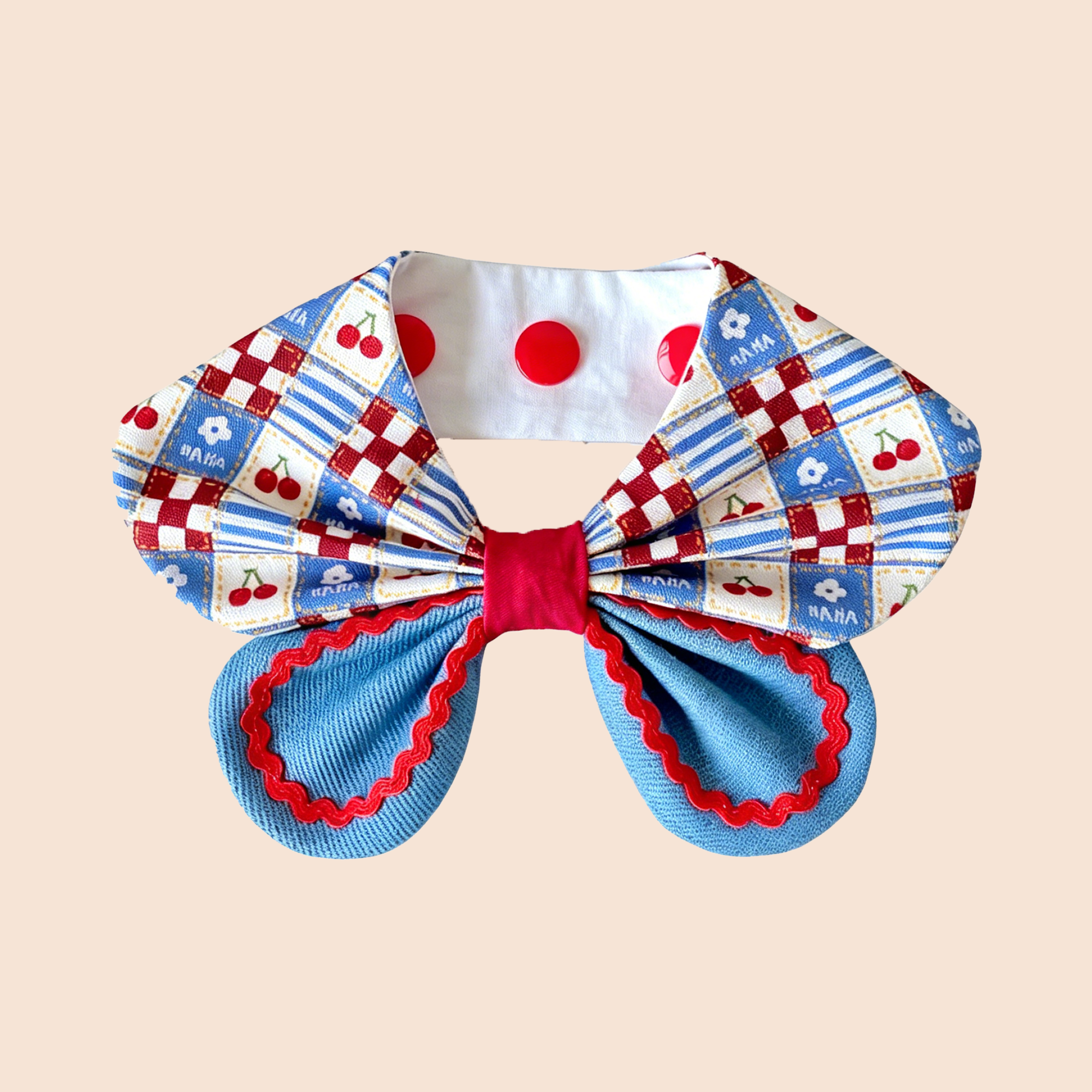 Oversized cherry patchwork print dog collar bandana with layered denim bow and red zigzag trim flat lay on white background