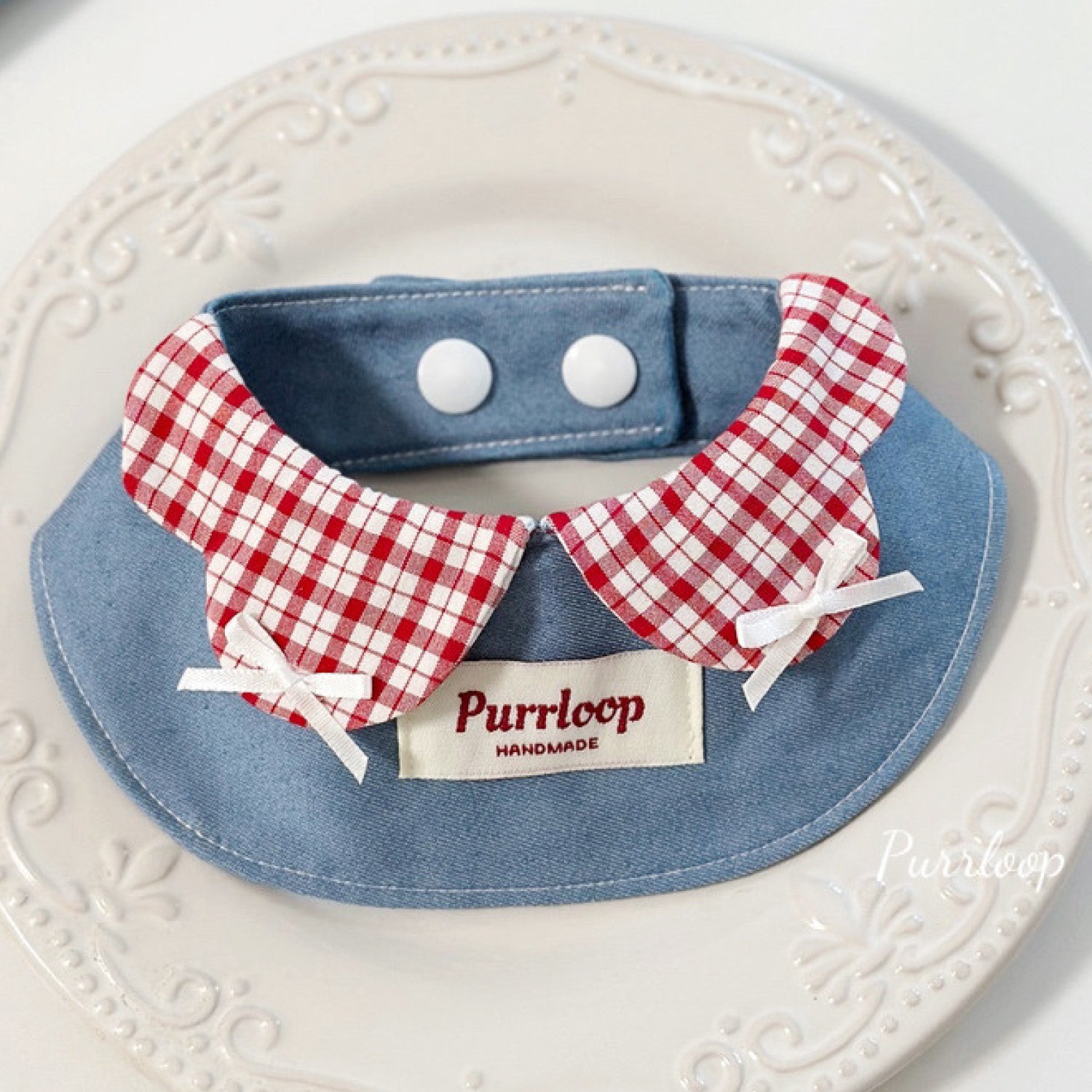 Classic red gingham bandana pet collar styled on white decorative plate