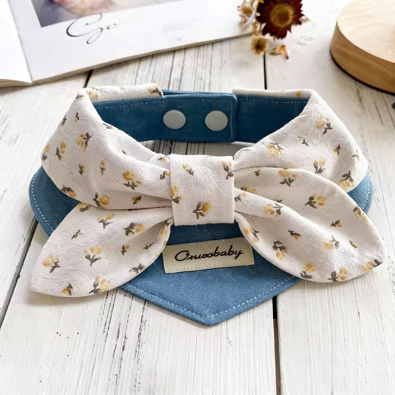 Cream floral print bow pet collar with blue denim bandana styled on wooden surface