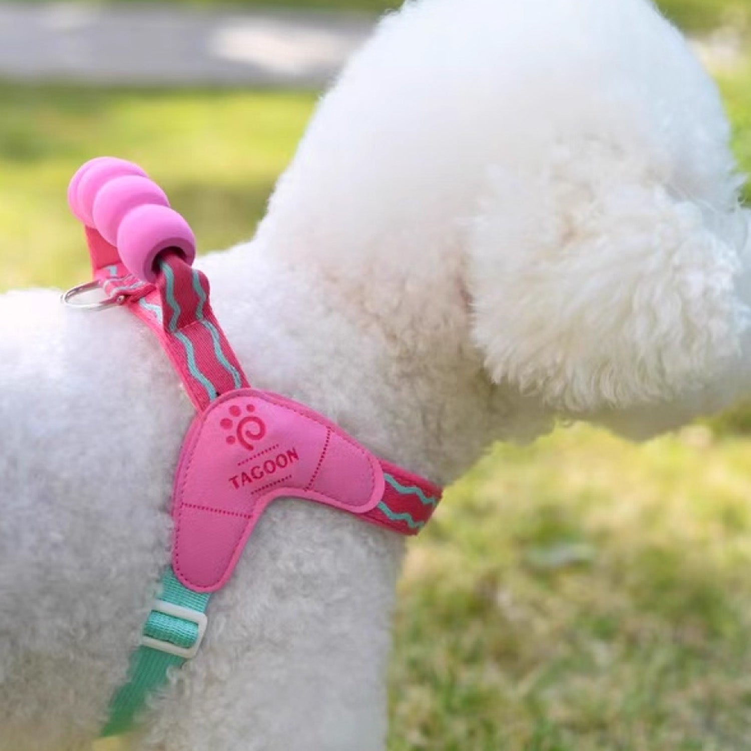 Back view of dog wearing pink vest harness with padded lifting handle