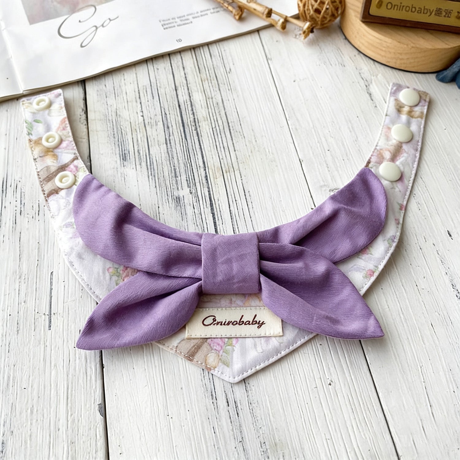 Purple lavender bow pet collar with floral bandana styled on wooden surface