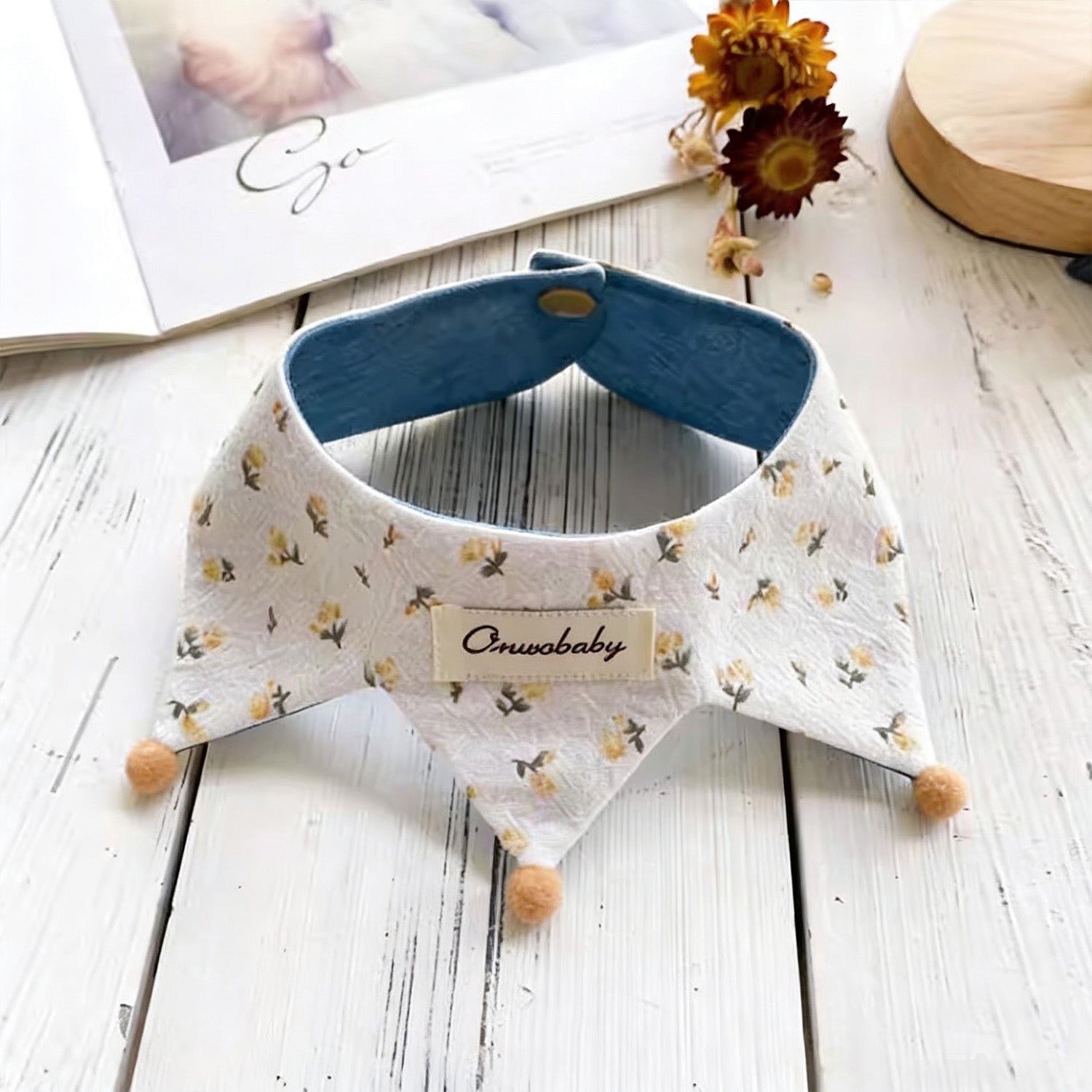 Floral pattern side of reversible pet bandana collar with wooden pom-poms