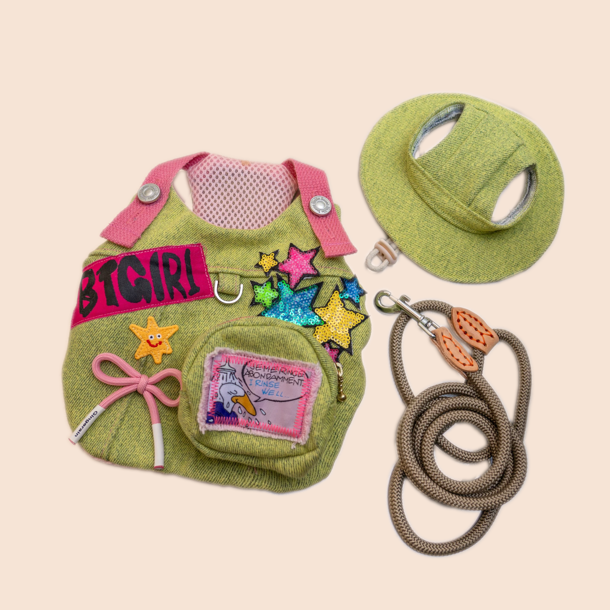 Green corduroy cat harness vest with sun hat and braided rope leash laid flat on white background