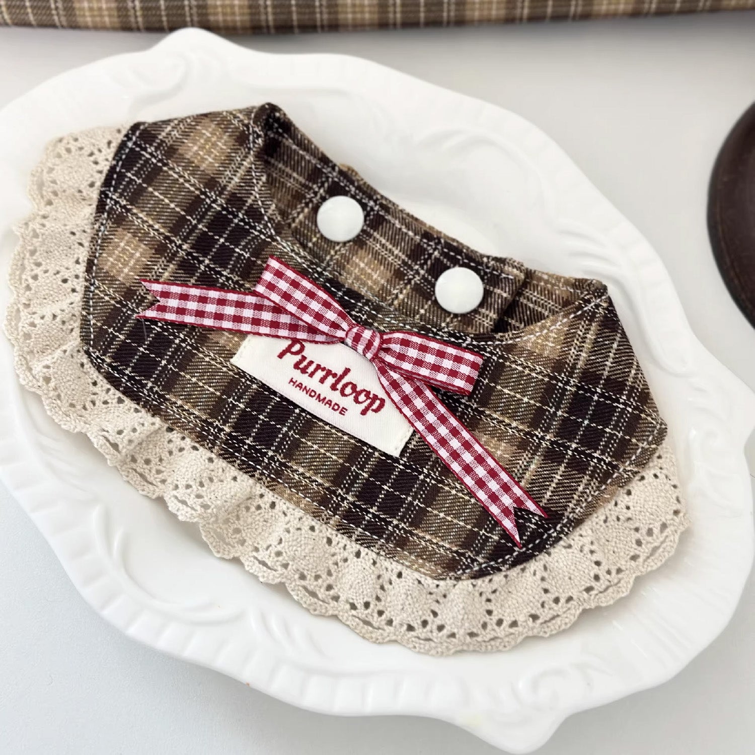 Brown check lace ruffle pet collar with gingham bow styled on plate