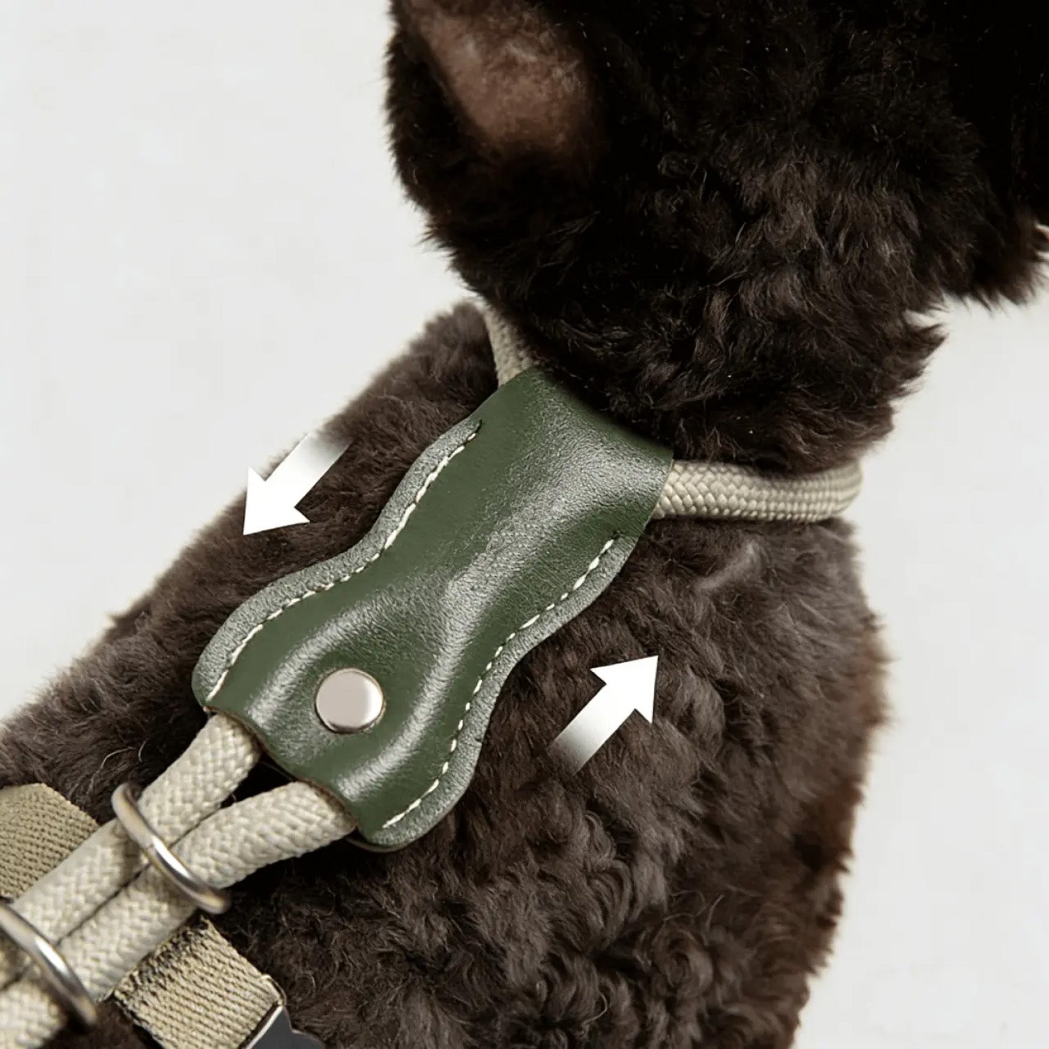 Close up of green leather adjustment pad on cat harness showing stitching and metal ring detail