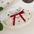 Load image into Gallery viewer, Cream ruffle pet collar with dot pattern and red ribbon styled on white plate
