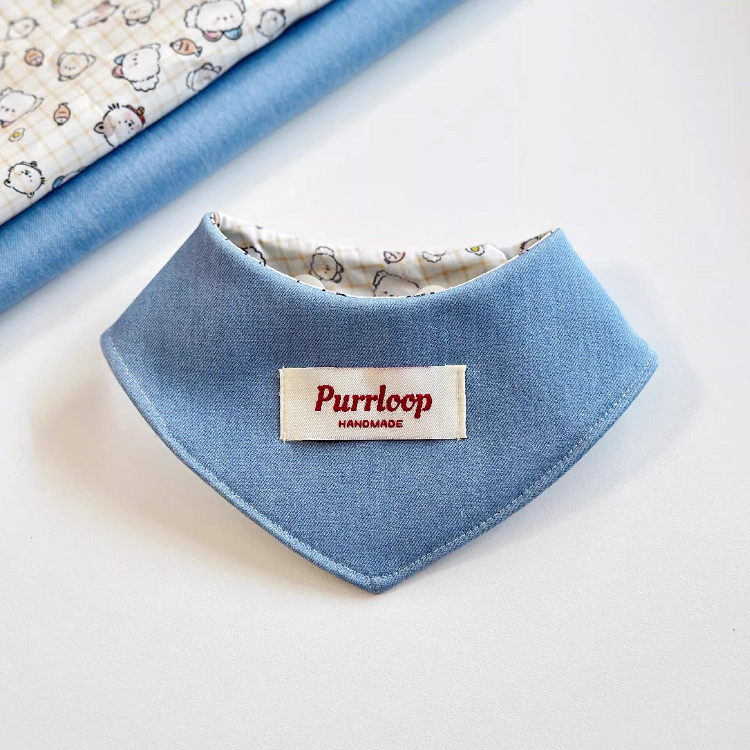 Solid blue side of reversible two-in-one pet bandana collar