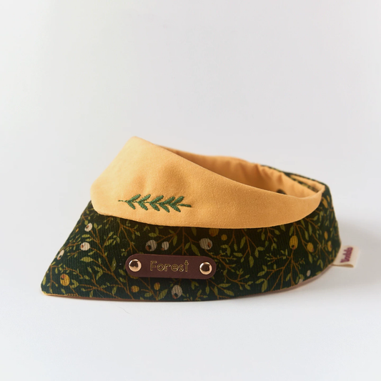 Side view of corduroy forest pet bandana showing botanical print texture and personalized engraved brown leather name tag