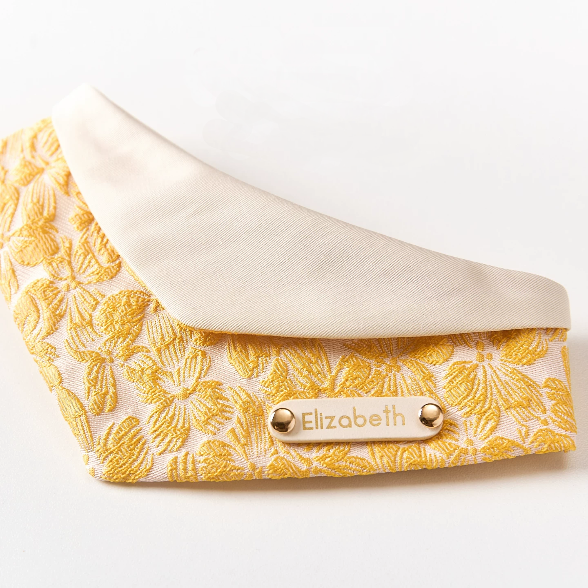 Front view of personalized gold jacquard pet bandana with cream cotton lining for cats and small dogs