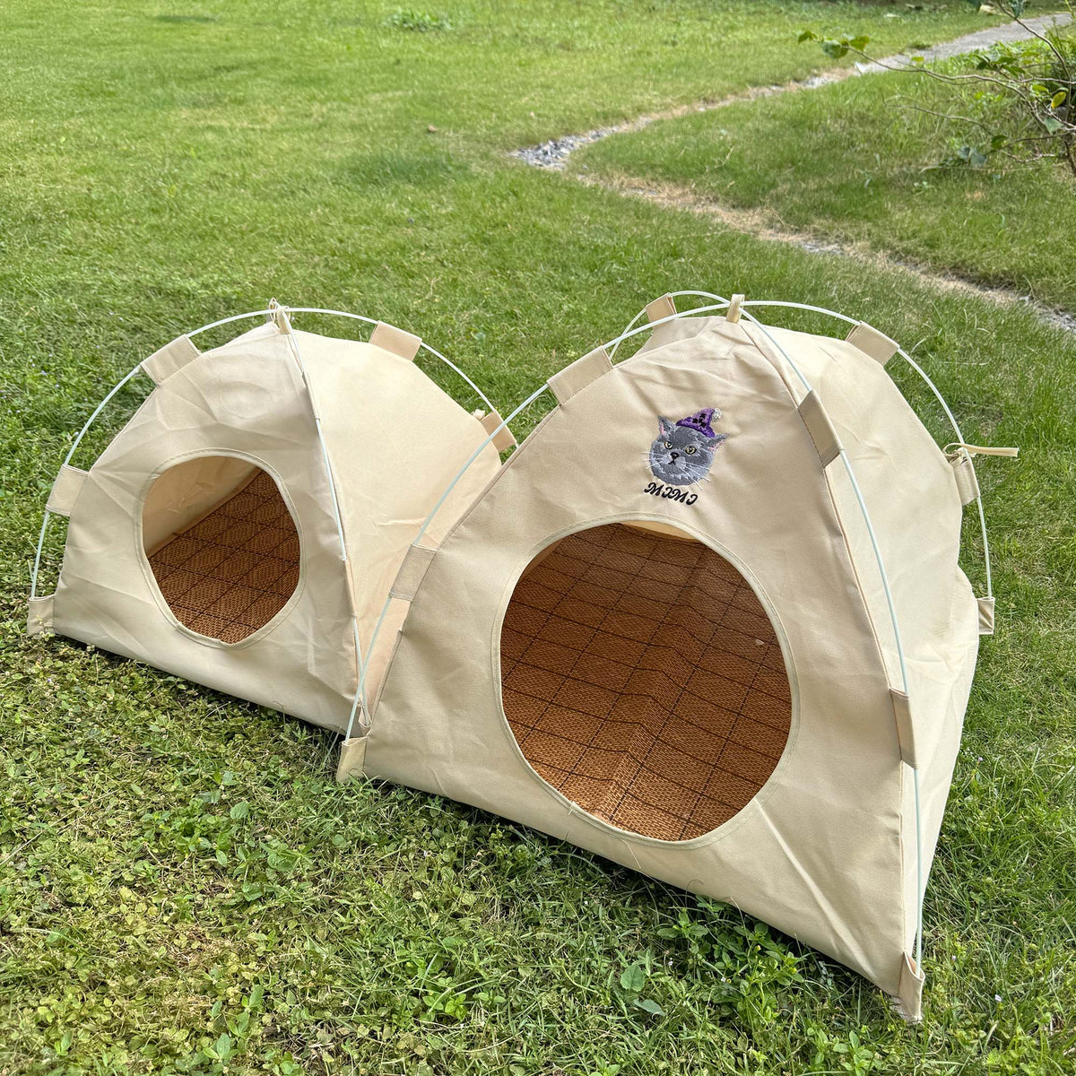 Side view of the Gravipaw embroidered cat tent bed on grass with the entrance flap open